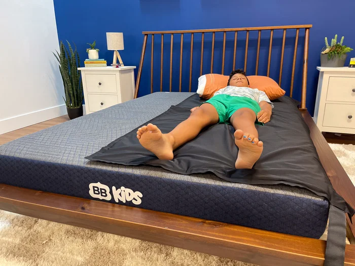 A 10-year-old boy lying on our pressure mat on top of the BB Kids mattress.