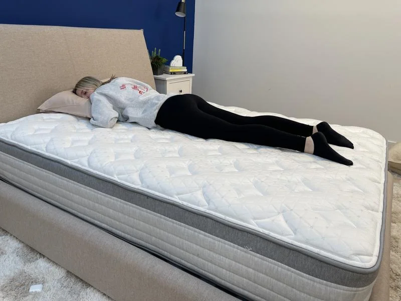Our tester stomach-sleeping on the Helix Plus Mattress