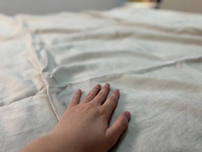 Our tester feeling the Quince European Linen Sheets