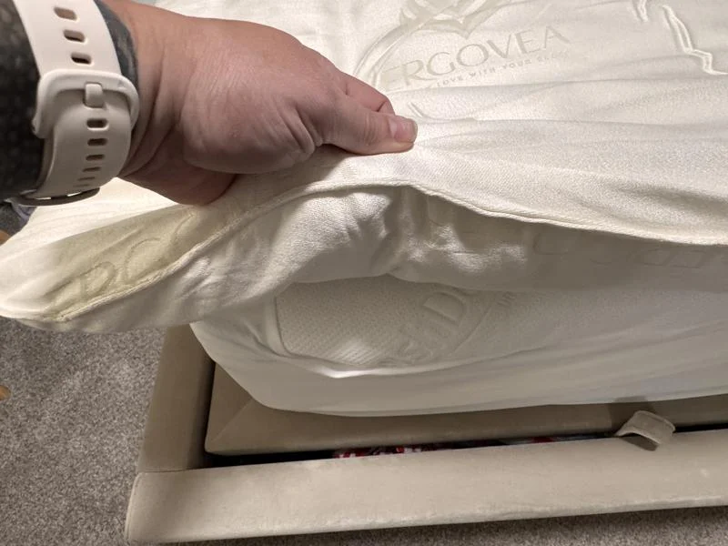 Our tester feeling the corner of a PlushBeds Natural Wool Mattress Topper