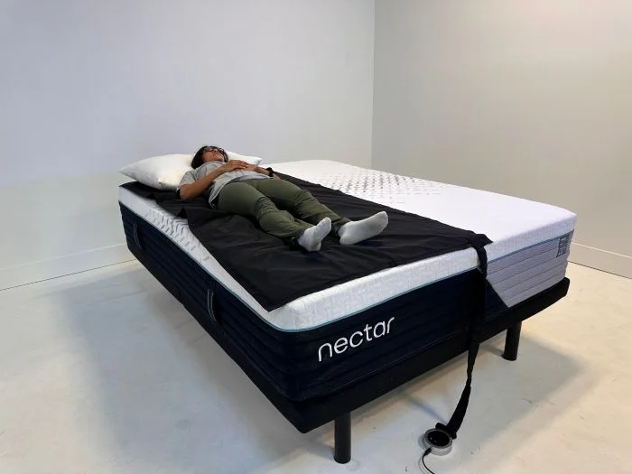 A lightweight tester rests on her back on a pressure mat on the Nectar Premier mattress