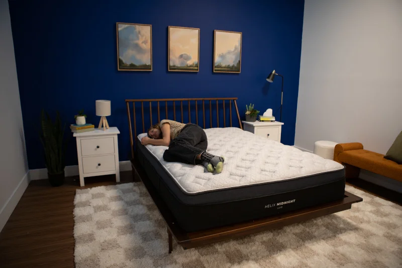 Our tester side-sleeping on a Helix Midnight Luxe Mattress