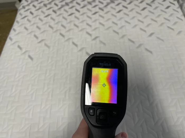 A closeup of a thermal gun reading the temperature of the Nectar Premier mattress after someone has rested on it for 5 minutes. The screen reads 73.9 degrees.
