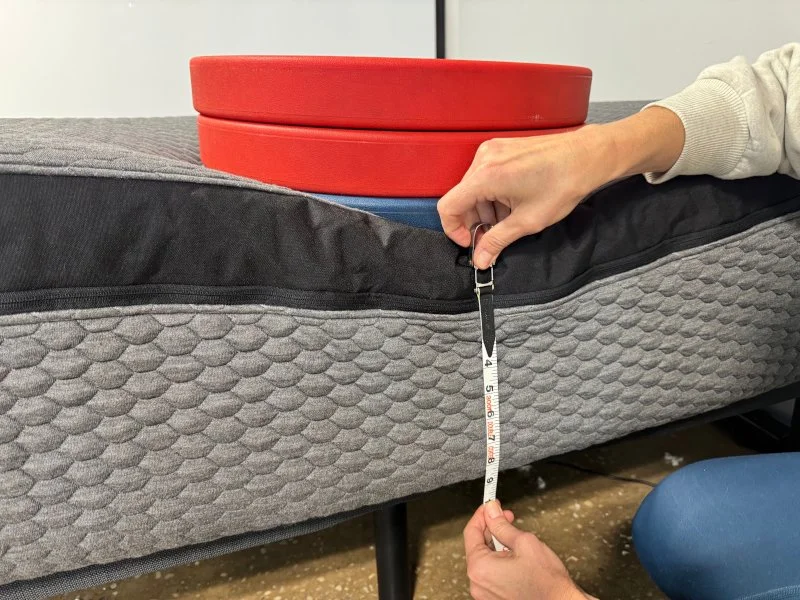 Measuring weight plates on the edge of a Layla Signature Hybrid Mattress