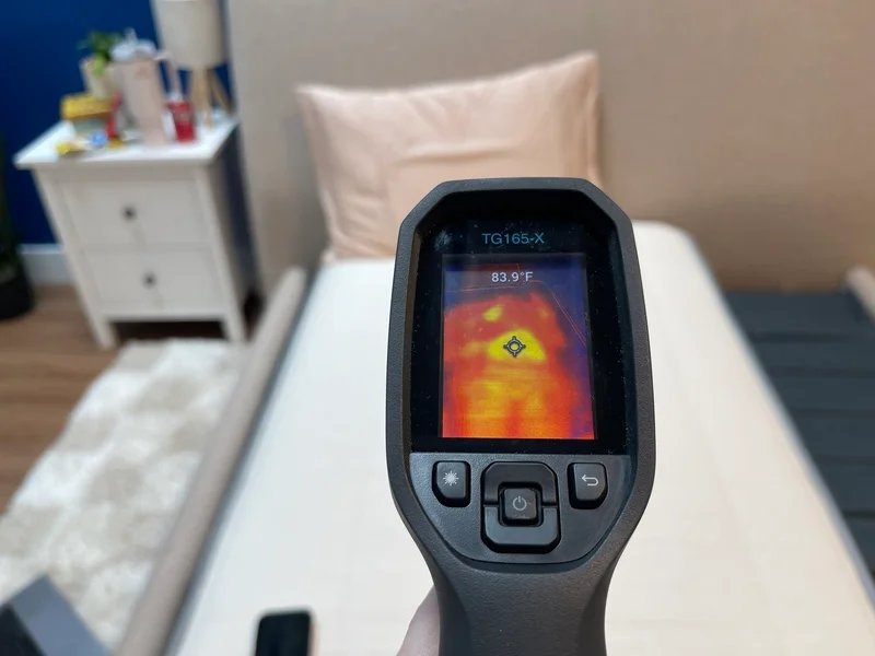 A mattress tester measures the surface temperature of the Nolah Nurture with a thermal gun.