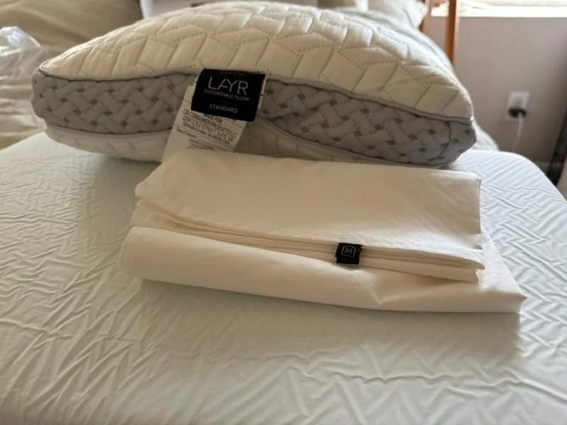Luxome LAYR Pillow with tags showing, next to the folded pillowcase.