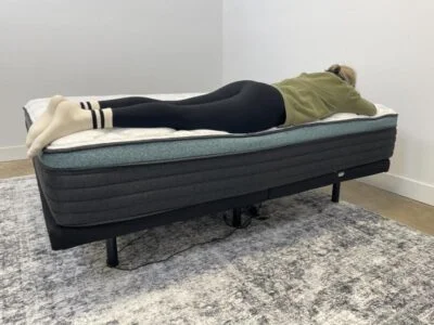Our tester performs a stomach-sleeping full body edge support test of the Helix Sunset Luxe Mattress
