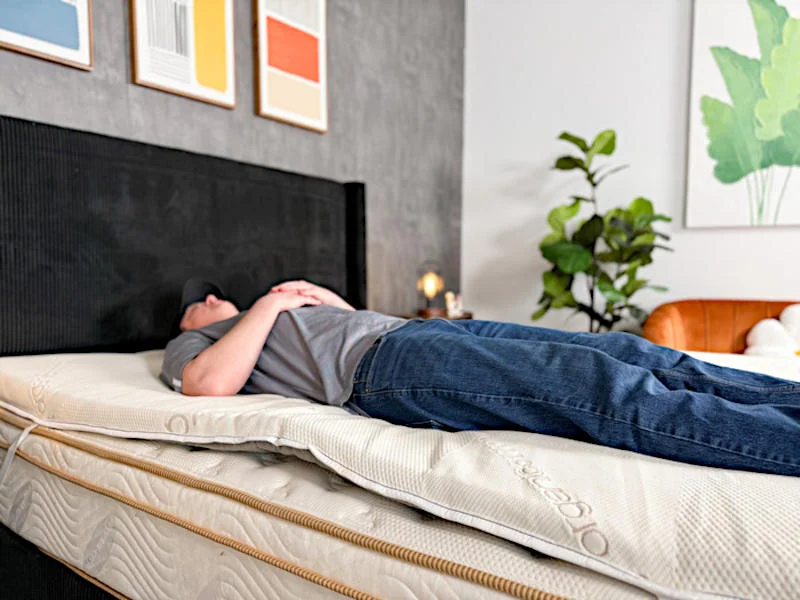 A person back sleeping on the Saatva Natural Latex Mattress Topper.