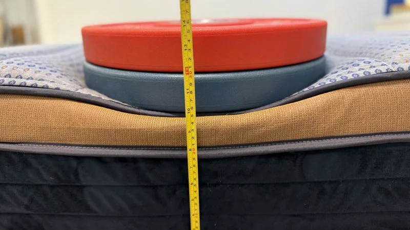 Our tester measures the deflection of weight plates along the edge of the Brooklyn Bedding CopperFlex Mattress