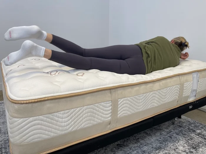 A woman rolling onto her side on the Saatva Rx mattress.