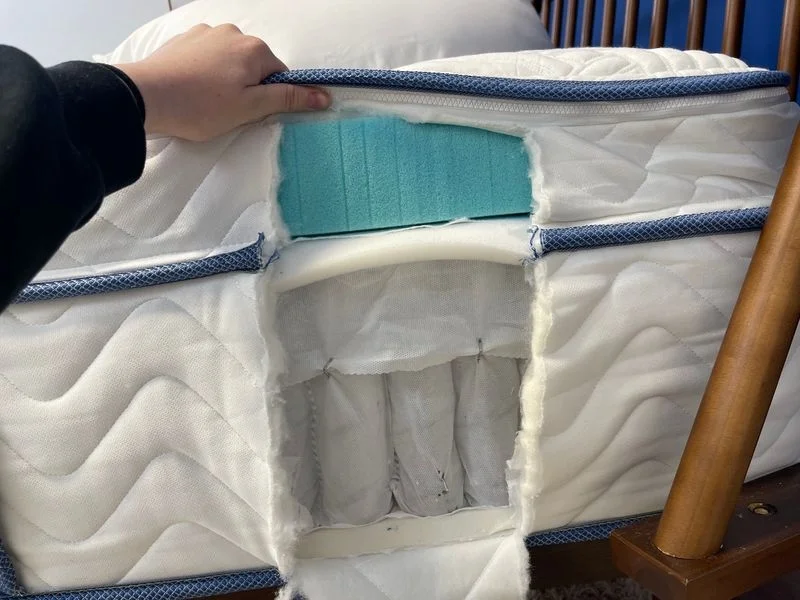 Looking at a cutaway to see the internal construction of a DLX Premier Hybrid mattress.