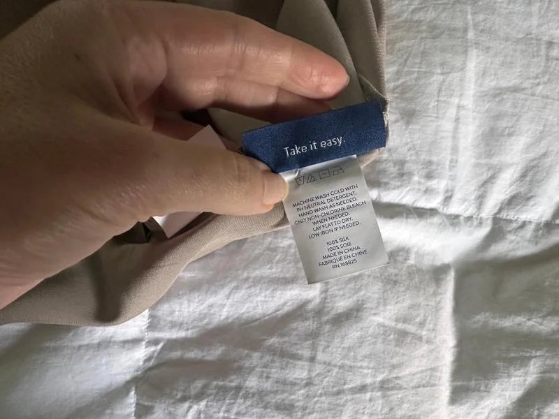 Looking at the care tag on a Brooklinen Mulberry Silk Pillowcase
