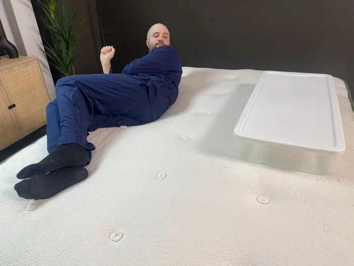A man lying on the Avocado Green next to a large bin of water. He's rolling back and forth to see if the water moves.