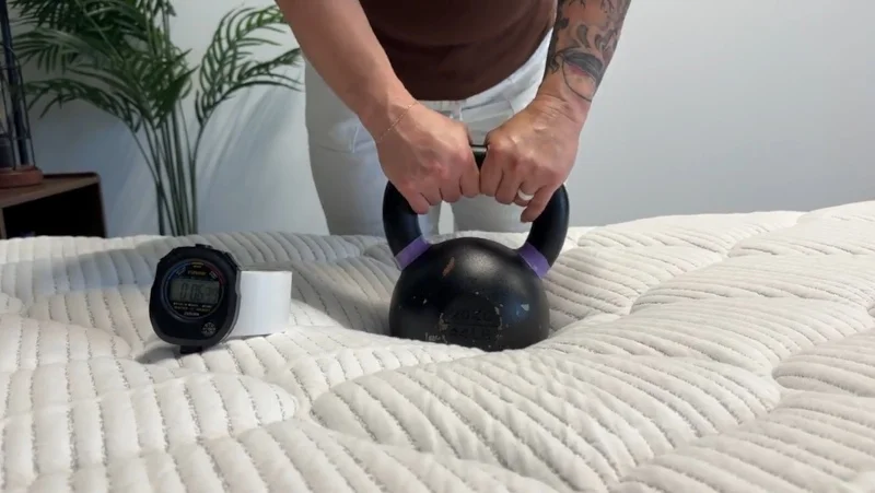 Our tester performs a response test on the DLX Premier Hybrid mattress.