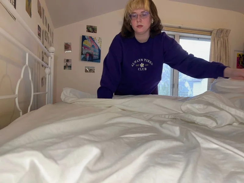 Our tester making a bed with a Boll & Branch Flannel Sheet Set