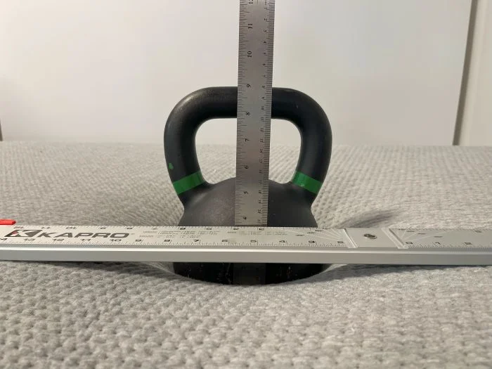 A kettlebell resting on top of a Casper The One mattress.