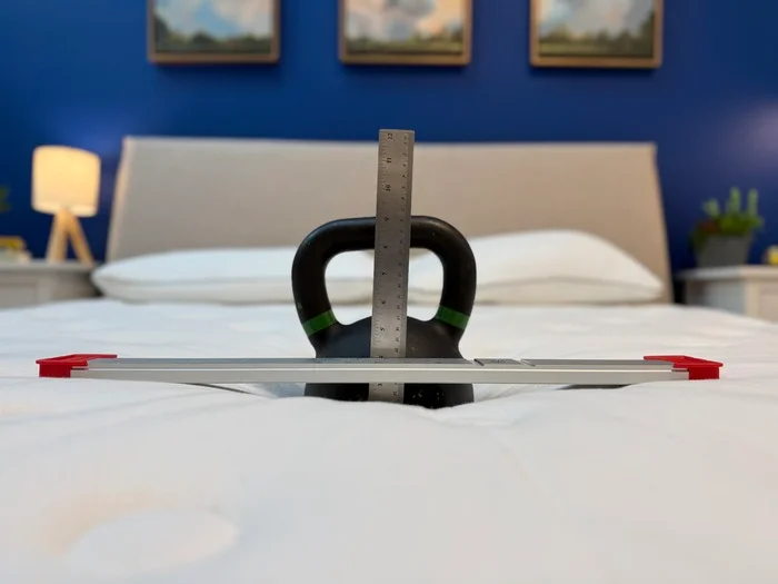 The sinkage test for the Silk & Snow Organic showing a kettlebell resting on the surface of the bed