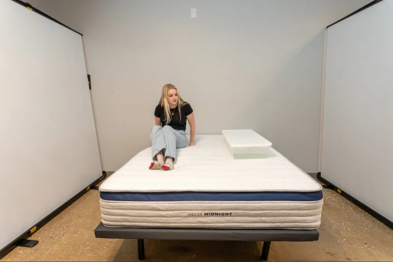 A mattress testing moving next to a bin full of water on the Helix Midnight to assess its motion isolation.
