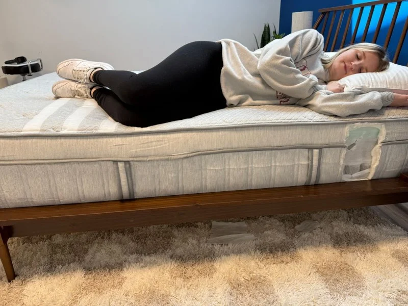 Our tester side-sleeping on a Leesa Plus Hybrid Mattress