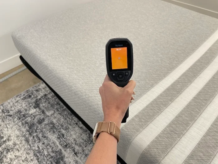 A closeup of someone using a thermal gun to read the neutral temperature of the Leesa Original mattress. The screen reads 66.2 degrees.