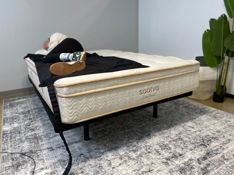 A person side-sleeping along the edge of a Saatva Latex Hybrid.