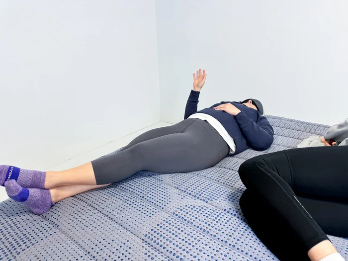 Two people perform motion transfer testing on a Brooklyn Bedding CopperFlex Mattress