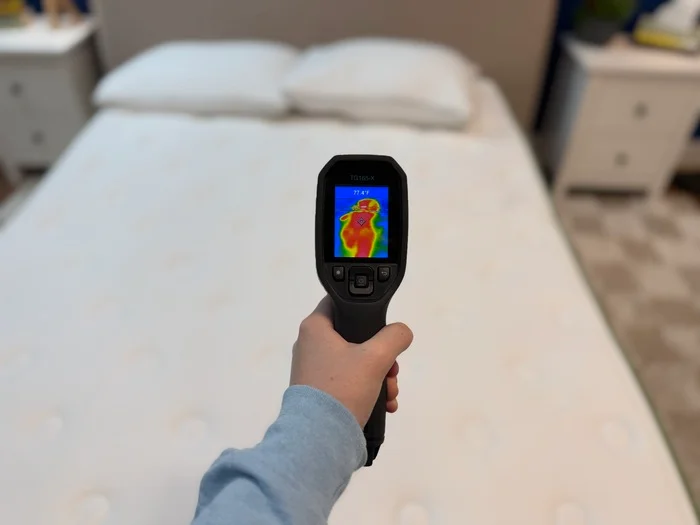 A hand points a thermal gun at the surface of the Silk & Snow Organic, taking the surface temperature of a thermal outline