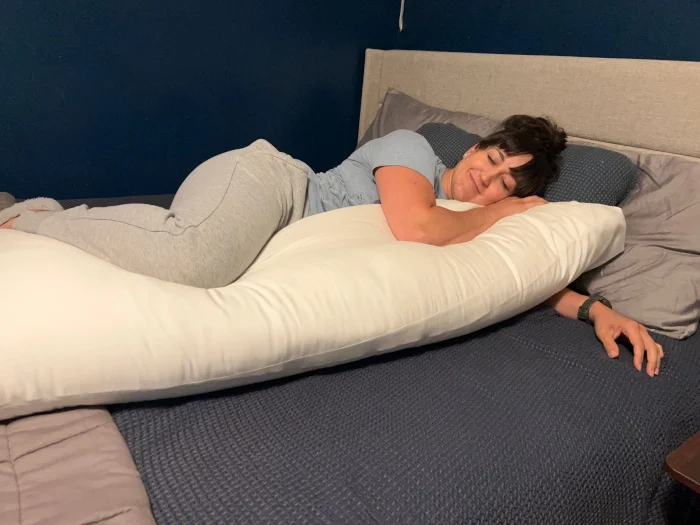 Our expert snuggling with a Cozy Earth Bamboo Down Alternative Body Pillow.