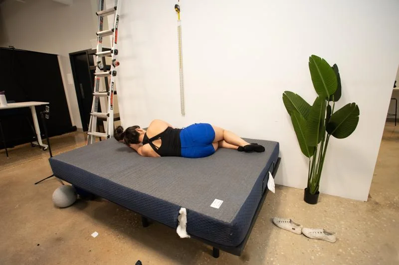 Our tester side-sleeping on the DreamFoam 8-Inch Essentials Mattress