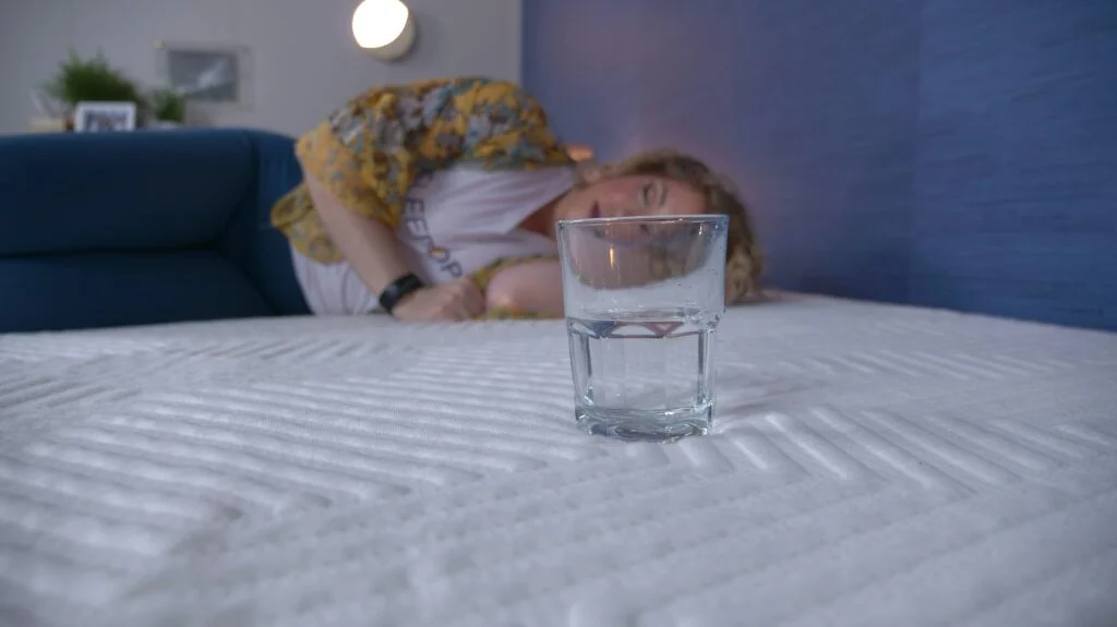 Nichole performing the water test on the Lucid Hybrid mattress.