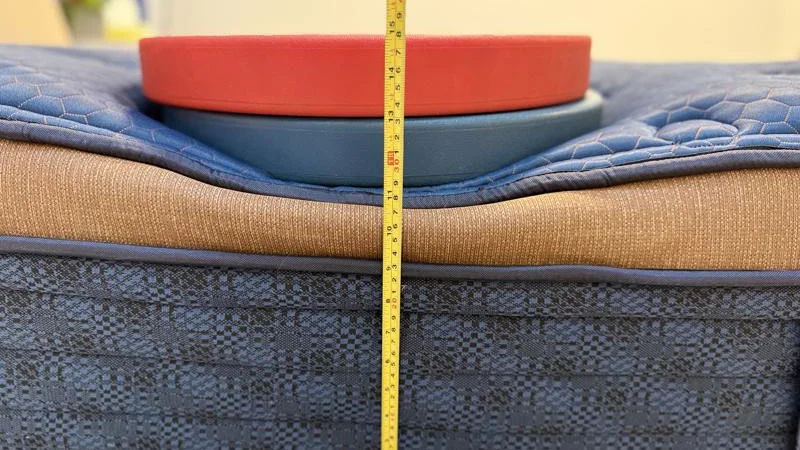 Our tester measures the deflection of weight plates along the edge of the Brooklyn Bedding Aurora Luxe mattress