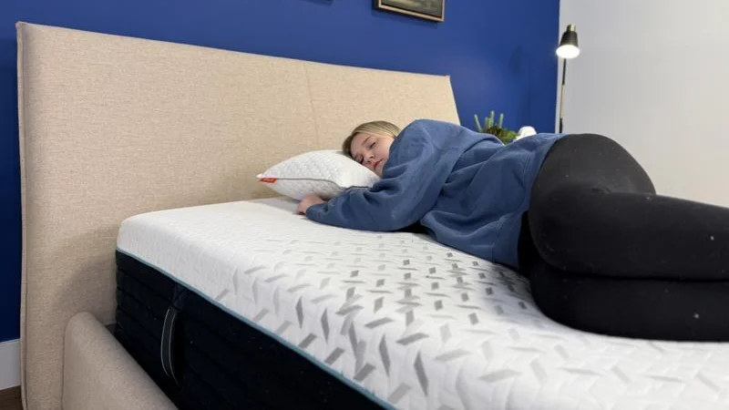 Our tester side-sleeping on the Nectar Premier Hybrid Mattress
