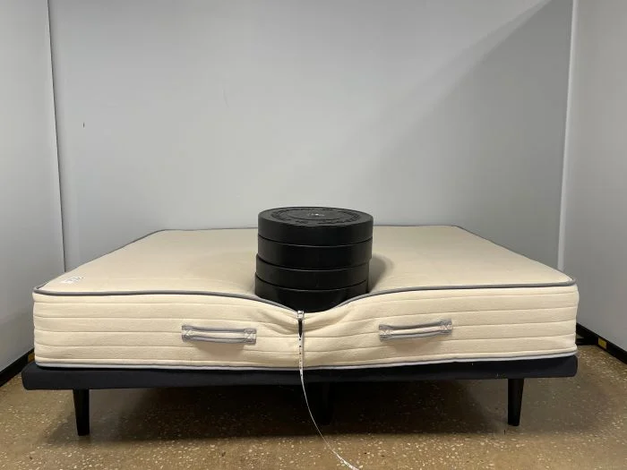 A stack of weights sitting on top of the Nolah Natural mattress.