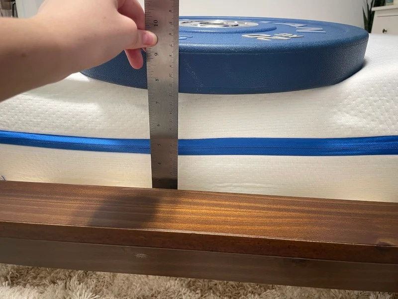 Measuring weight plates on the edge of a Nectar Kids Mattress