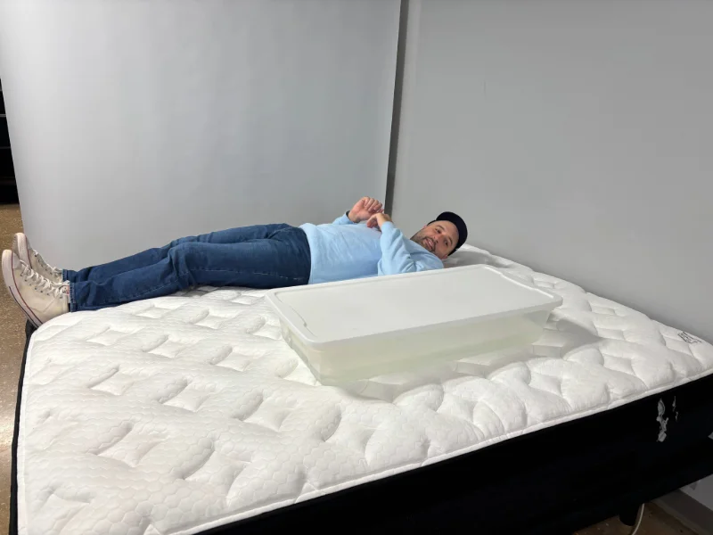 A mattress tester evaluating the motion isolation of the Nolah Evolution Comfort Plus.