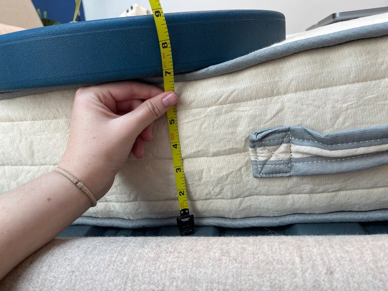 A mattress tester uses weights and a tape measure to assess the edge support of the Nolah Nurture.