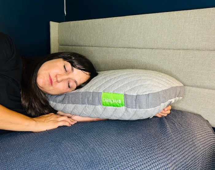 A woman side-sleeping on a Cariloha Pillow.