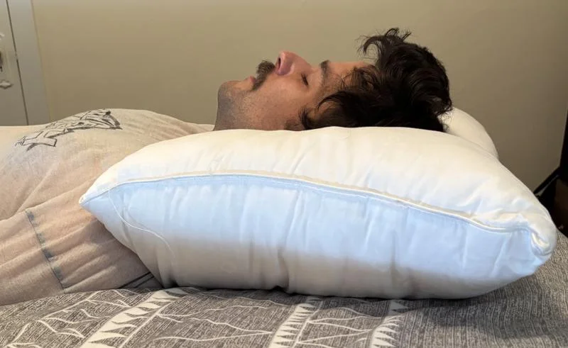 Our tester back-sleeping on a Saatva Down Alternative Pillow