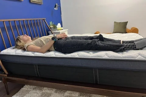 Our tester performs a back-sleeping Full Body edge support test of the Helix Midnight Luxe Mattress