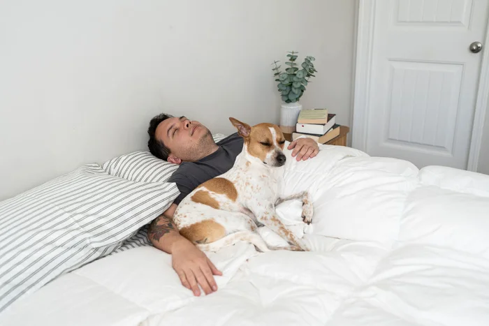 Tester Kenny Timper napping with the dog on a Feathered Friends 700 Bavarian Down Comforter