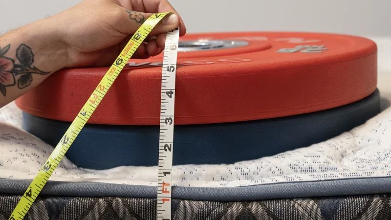 Our tester measures the sinkage from weight plates along the edge of the Serta Perfect Sleeper Cascade Range Mattress