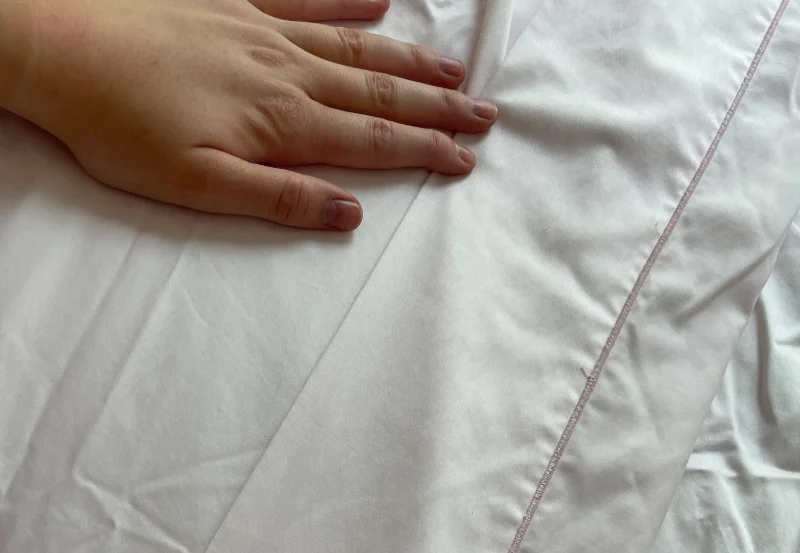 Our tester feeling a Cuddledown Sateen Sheet Set