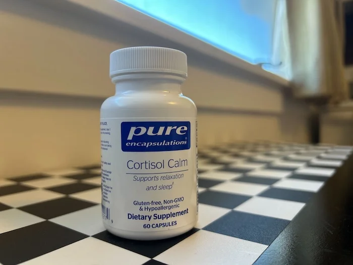 A bottle of Pure Encapsulations Cortisol Calm on a checkered kitchen counter.