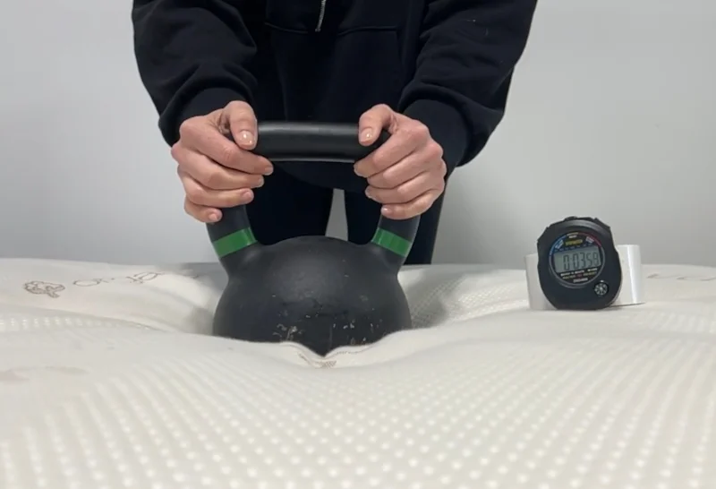 Our expert performing a responsiveness test on a Saatva Latex Hybrid.