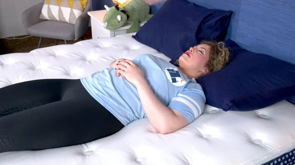 A woman sleeping on her back on the WinkBed.