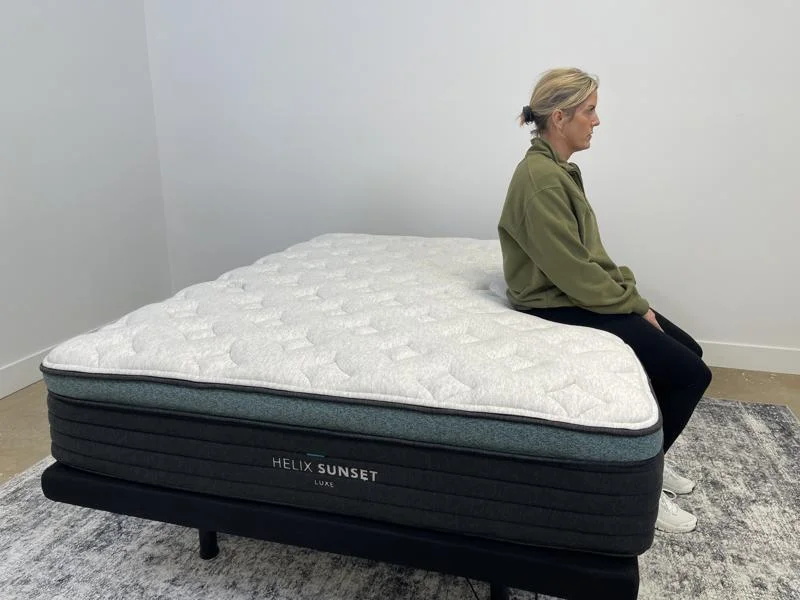 Our tester does a seated edge support test on the Helix Sunset Luxe Mattress