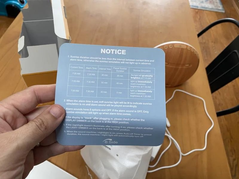 Our product tester holds an instruction card for the Reacher Sunrise Alarm Clock