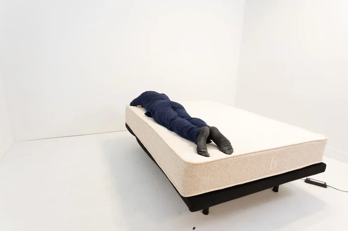 A man lying on his stomach on the Birch Natural mattress.