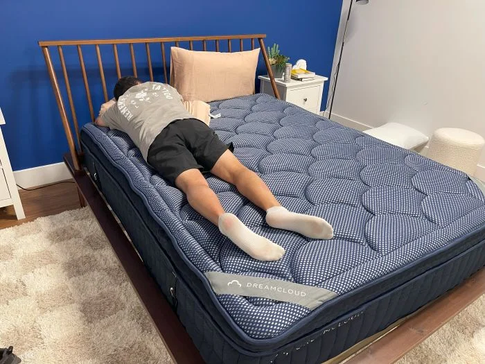 A man sleeps on his stomach on the Dreamcloud Luxe Hybrid