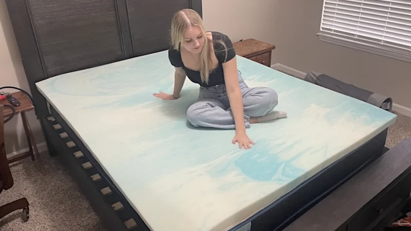Our tester gets a feel for the Brooklyn Bedding Gel Swirl Memory Foam Mattress Topper